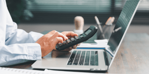 Office worker at a desk with a calculator working on value management